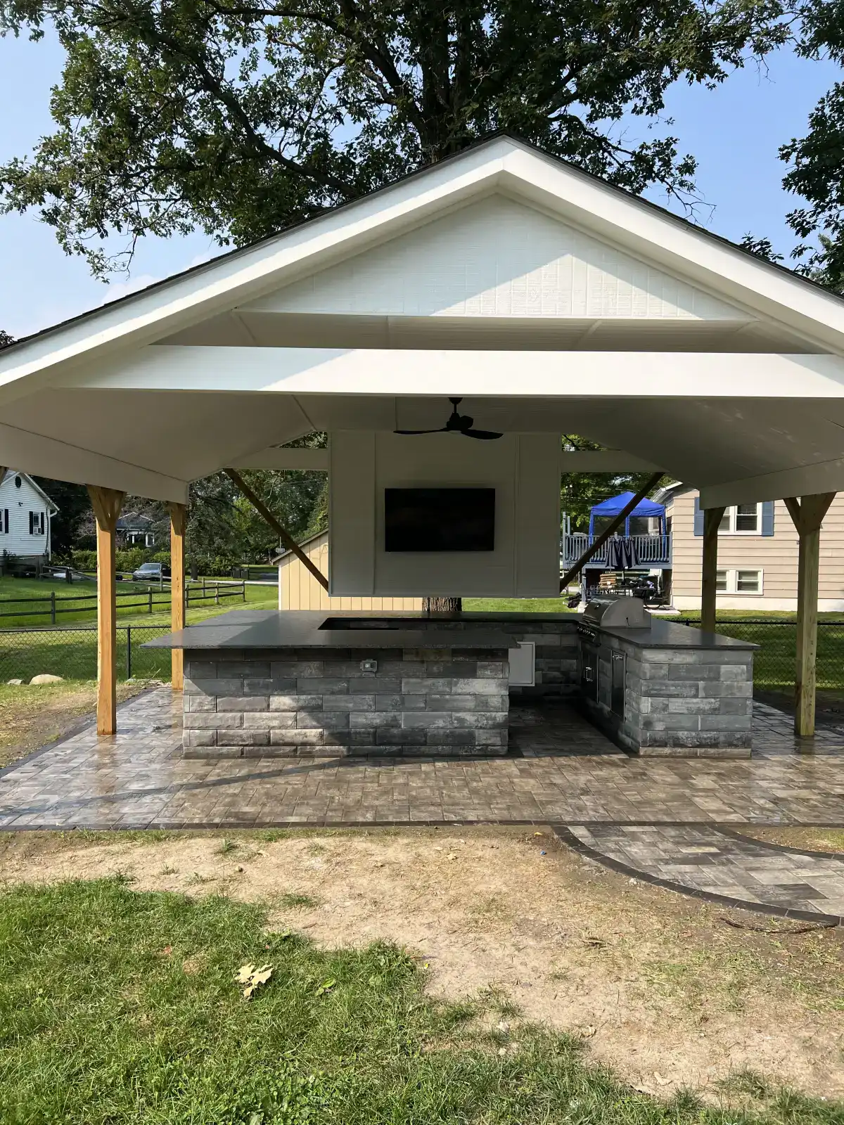 Covered outdoor kitchen with a built-in grill and stone counters